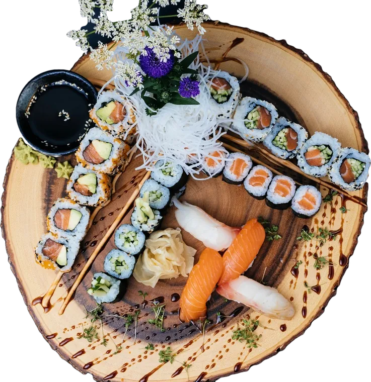 Sushi-Platte auf einer Baumscheibe: Maki, Inside-Out-Rollen, Nigiri mit Lachs und Butterfisch, Ingwer und Sojasauce